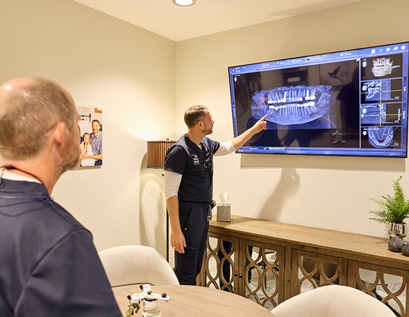 Dentist pointing at dental bridge on patient’s X-ray