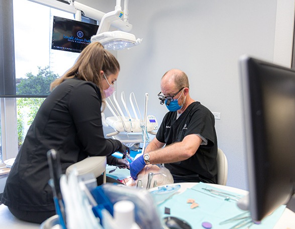 Dentists examining older woman’s mouth