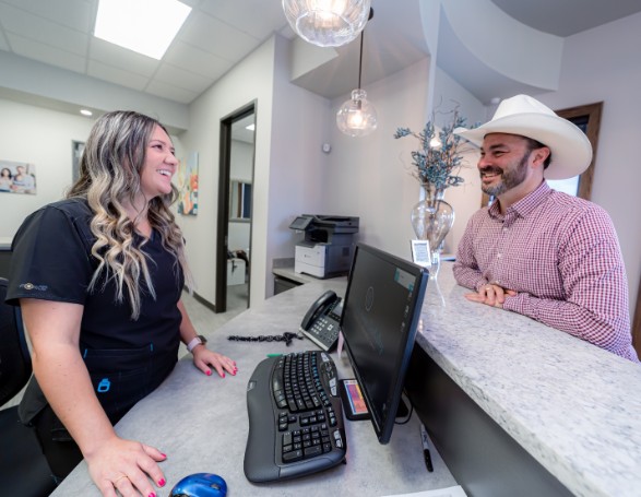 Wright Naeger Dentistry team member assisting patient at front desk