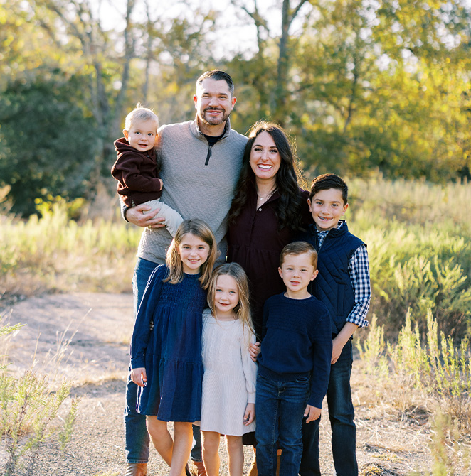 Doctor Naeger smiling with several kids in the dental office