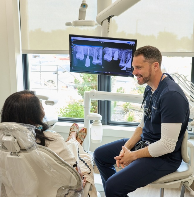 Dentist and an assistant performing a dental procedure on a patient