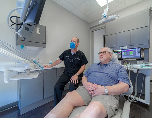 Dr. Wright and patient looking at monitor, wearing serious expressions