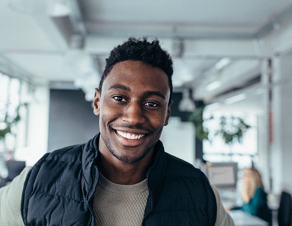 Man in dental office showing off smile